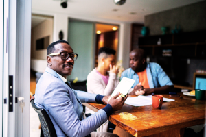 A couple meet with their trusted financial advisor around the kitchen table. The advisor has explained the advisory variable universal life product to them, and they are considering its tax-favored benefits.